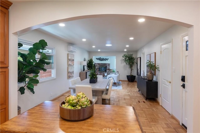2054 Pattiz Ave, Long Beach, CA 90815 - dining space with arched walkways, an AC wall unit, a fireplace, and recessed lighting