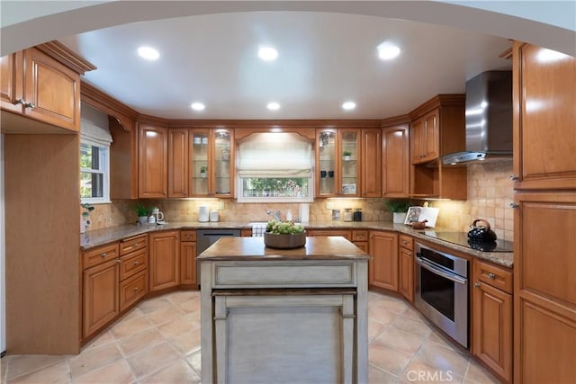 2054 Pattiz Ave, Long Beach, CA 90815 - kitchen featuring stainless steel appliances, wall chimney range hood, arched walkways, tasteful backsplash, and light stone counters