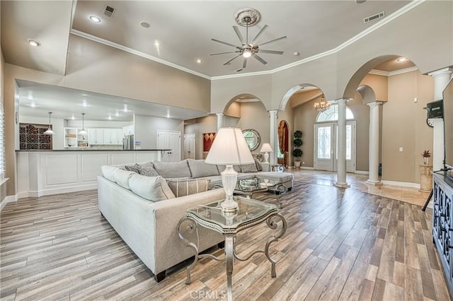 2457 Remington Ct, Merced, CA 95340 - living room featuring decorative columns, a ceiling fan, light wood-style floors, arched walkways, and crown molding