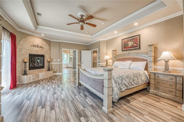 2457 Remington Ct, Merced, CA 95340 - bedroom featuring a tray ceiling, wood finished floors, a tiled fireplace, and ornamental molding