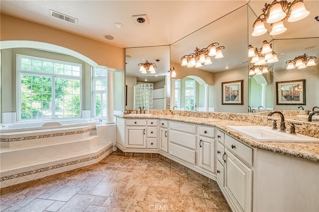 2457 Remington Ct, Merced, CA 95340 - bathroom featuring ornate columns, plenty of natural light, double vanity, and a garden tub
