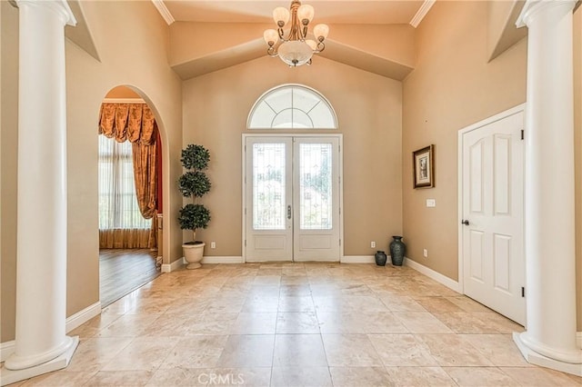 2457 Remington Ct, Merced, CA 95340 - foyer entrance featuring ornate columns, arched walkways, high vaulted ceiling, a chandelier, and french doors