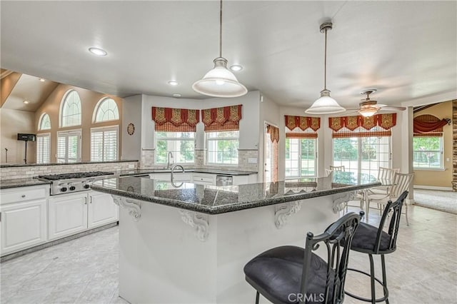 2457 Remington Ct, Merced, CA 95340 - kitchen featuring stainless steel gas stovetop, a breakfast bar area, healthy amount of natural light, and recessed lighting