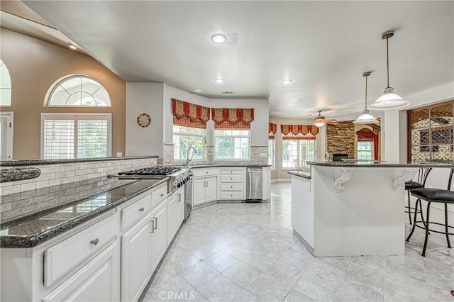 2457 Remington Ct, Merced, CA 95340 - kitchen with tasteful backsplash, a kitchen bar, ceiling fan, white cabinets, and recessed lighting