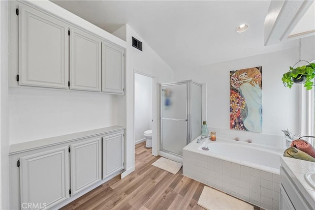 2981 Pembroke Cir, Corona, CA 92879 - bathroom with a stall shower, a garden tub, wood finished floors, vanity, and lofted ceiling