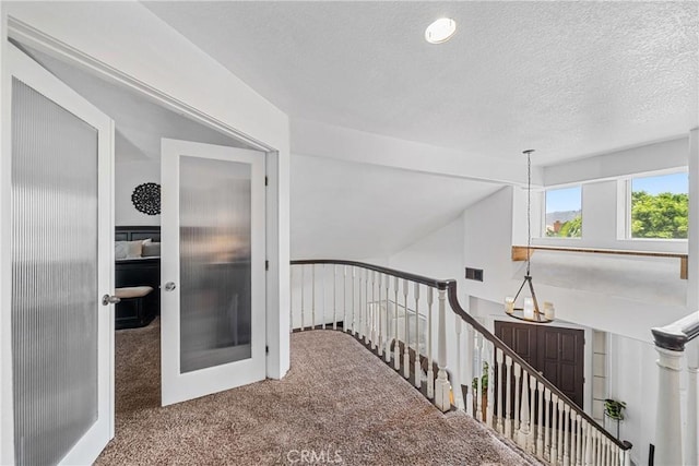 2981 Pembroke Cir, Corona, CA 92879 - hallway featuring an upstairs landing, carpet flooring, a textured ceiling, and vaulted ceiling