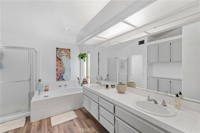 2981 Pembroke Cir, Corona, CA 92879 - bathroom with double vanity, a garden tub, a stall shower, wood finished floors, and lofted ceiling