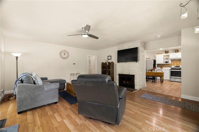 401 W 6th Ave, Chico, CA 95926 - living area with a stone fireplace, light wood-style flooring, and a ceiling fan