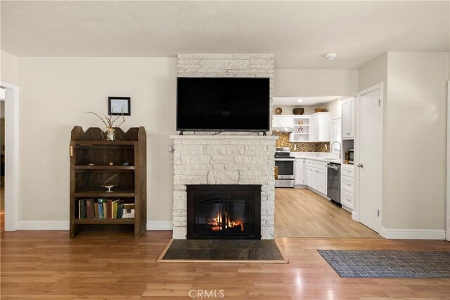 401 W 6th Ave, Chico, CA 95926 - living area with light wood-style flooring and a stone fireplace
