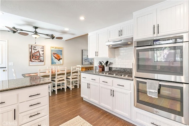 248 Hemlock Dr, Lake Arrowhead, CA 92352 - kitchen with appliances with stainless steel finishes, dark wood-style floors, white cabinets, backsplash, and recessed lighting