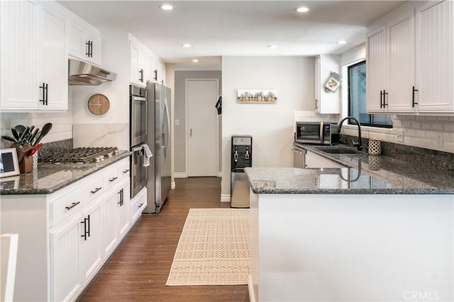 248 Hemlock Dr, Lake Arrowhead, CA 92352 - kitchen with appliances with stainless steel finishes, under cabinet range hood, tasteful backsplash, recessed lighting, and dark stone countertops