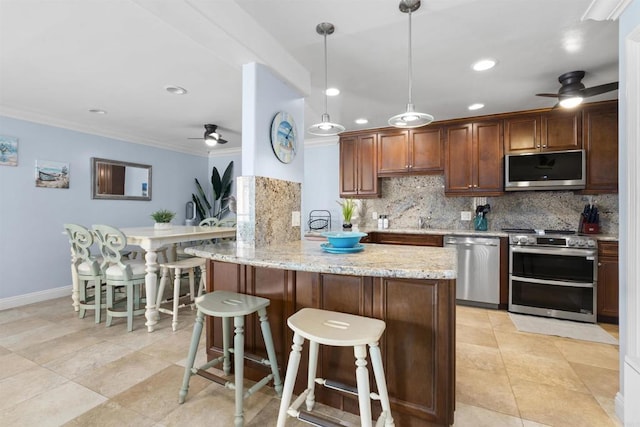 804 N The Strand Unit 11, Oceanside, CA 92054 - kitchen with appliances with stainless steel finishes, a ceiling fan, tasteful backsplash, crown molding, and light stone counters