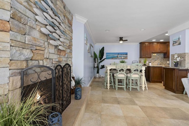 804 N The Strand Unit 11, Oceanside, CA 92054 - dining area featuring ornamental molding, a ceiling fan, a stone fireplace, and recessed lighting