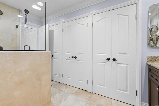 804 N The Strand Unit 11, Oceanside, CA 92054 - full bath featuring a closet, tiled shower, vanity, crown molding, and tile patterned flooring
