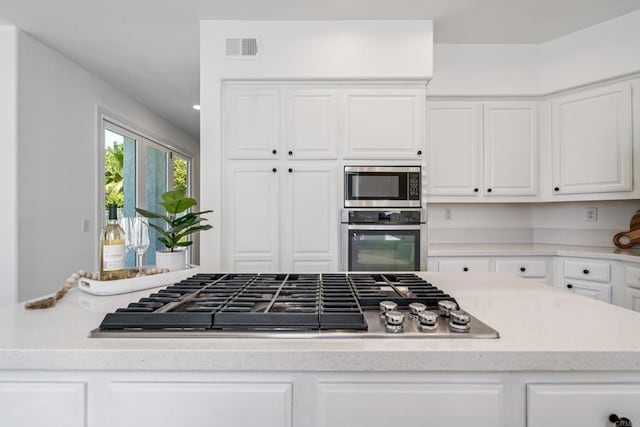 4926 Colusa Dr, Oceanside, CA 92056 - kitchen with stainless steel appliances, white cabinetry, and light countertops