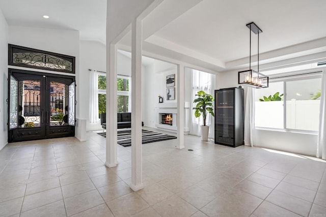 4926 Colusa Dr, Oceanside, CA 92056 - foyer entrance featuring french doors, light tile patterned floors, a warm lit fireplace, recessed lighting, and a tray ceiling