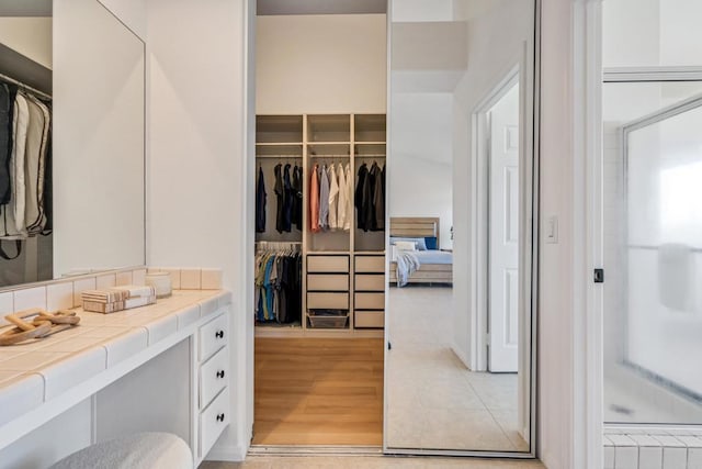 4926 Colusa Dr, Oceanside, CA 92056 - full bathroom featuring vanity, a spacious closet, wood finished floors, and a shower