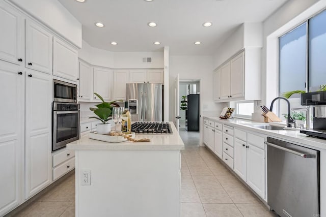 4926 Colusa Dr, Oceanside, CA 92056 - kitchen with appliances with stainless steel finishes, a center island, plenty of natural light, light tile patterned flooring, and recessed lighting