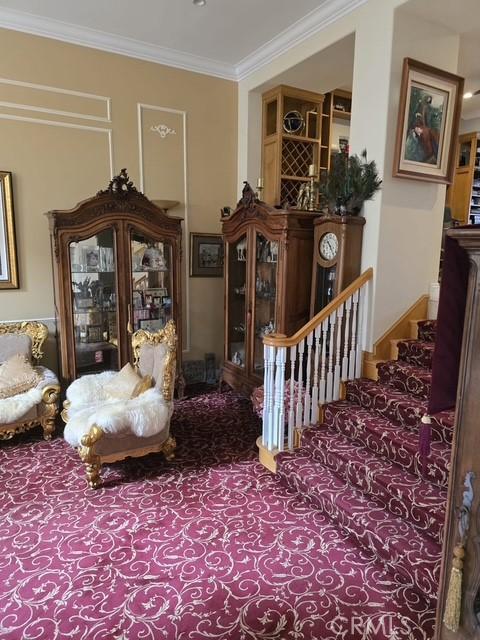 11 Chandon, Newport Coast, CA 92657 - sitting room with crown molding, stairway, and carpet floors