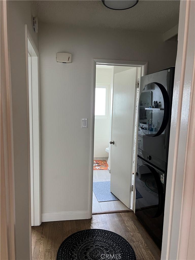 801 E 1st St Unit 15, Long Beach, CA 90802 - laundry area featuring estacked washer and dryer and wood finished floors