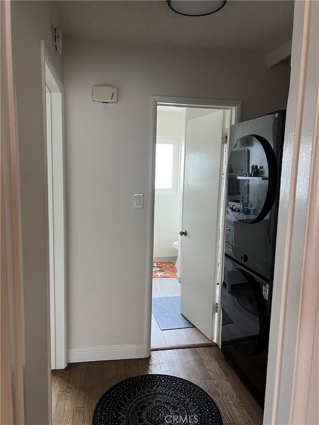801 E 1st St Unit 15, Long Beach, CA 90802 - laundry area featuring estacked washer and dryer and wood finished floors