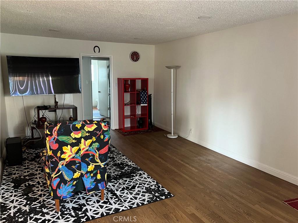 801 E 1st St Unit 15, Long Beach, CA 90802 - living area with wood finished floors and a textured ceiling