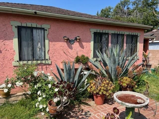 13567 Eldridge Ave, Sylmar, CA 91342 - view of side of property featuring stucco siding and a patio area
