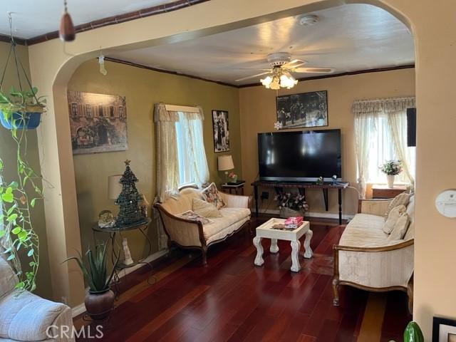 13567 Eldridge Ave, Sylmar, CA 91342 - living room with arched walkways, wood finished floors, ceiling fan, and crown molding