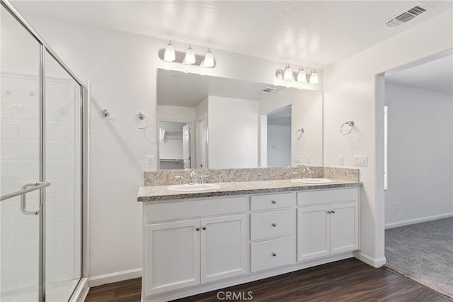 6648 E Yale, Fresno, CA 93727 - bathroom with double vanity, a shower stall, and wood finished floors
