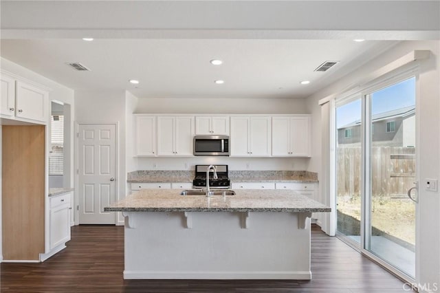 6648 E Yale, Fresno, CA 93727 - kitchen featuring stainless steel microwave, dark wood-style floors, white cabinetry, light stone countertops, and recessed lighting