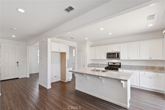 6648 E Yale, Fresno, CA 93727 - kitchen featuring stainless steel appliances, white cabinetry, dark wood-style flooring, light stone countertops, and recessed lighting