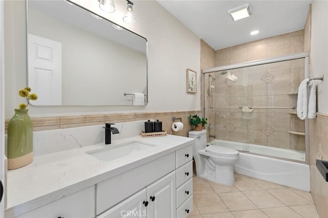 16186 Mount Gist Cir, Fountain Valley, CA 92708 - bathroom with vanity, tile patterned flooring, shower / bath combination with glass door, tile walls, and wainscoting