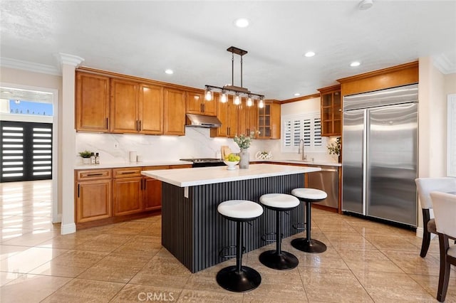 16186 Mount Gist Cir, Fountain Valley, CA 92708 - kitchen featuring appliances with stainless steel finishes, crown molding, brown cabinets, light countertops, and light tile patterned floors