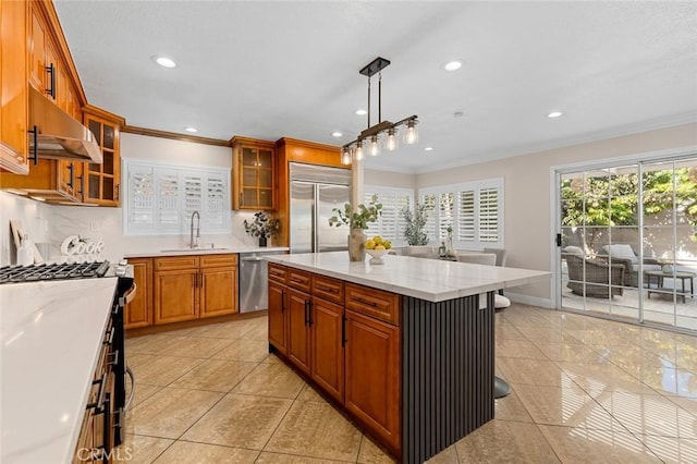 16186 Mount Gist Cir, Fountain Valley, CA 92708 - kitchen featuring stainless steel appliances, under cabinet range hood, ornamental molding, recessed lighting, and brown cabinetry