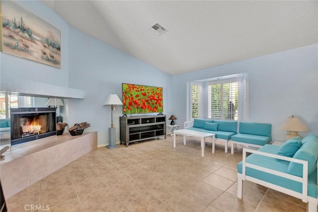 31121 Avenida Ximino, Cathedral City, CA 92234 - living room with lofted ceiling, a tile fireplace, tile patterned flooring, and a textured ceiling