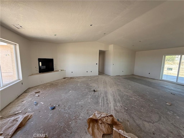 9570 Mescalero Rd, Phelan, CA 92371 - unfurnished living room with vaulted ceiling and a textured ceiling