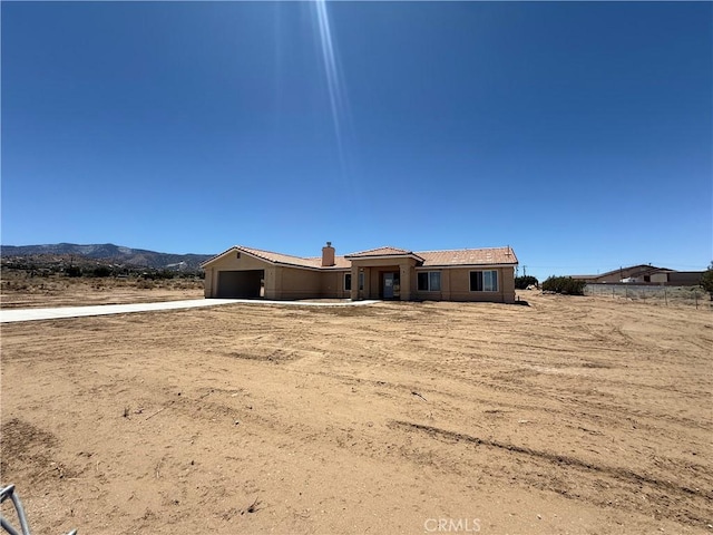 9570 Mescalero Rd, Phelan, CA 92371 - view of front facade with a garage, concrete driveway, and a mountain view