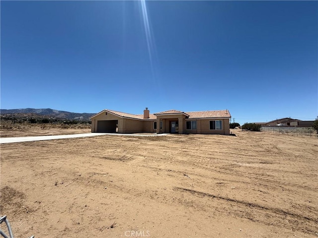 9570 Mescalero Rd, Phelan, CA 92371 - view of front of home featuring an attached garage, driveway, and a mountain view