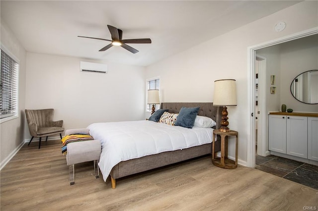4574 Avenida Del Sol, Joshua Tree, CA 92252 - bedroom featuring a wall mounted air conditioner, multiple windows, wood finished floors, and a ceiling fan