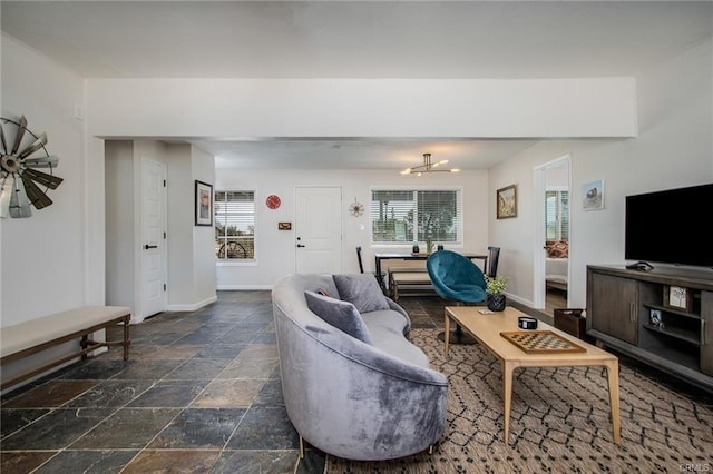 4574 Avenida Del Sol, Joshua Tree, CA 92252 - living area with stone tile floors, plenty of natural light, and a chandelier
