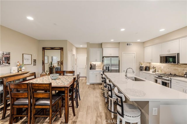 300 Farmhouse Dr Unit 3, Simi Valley, CA 93065 - kitchen with stainless steel appliances, light countertops, an island with sink, white cabinets, and recessed lighting