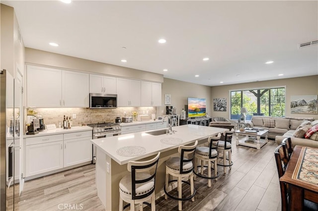 300 Farmhouse Dr Unit 3, Simi Valley, CA 93065 - kitchen with stainless steel appliances, open floor plan, white cabinets, and recessed lighting