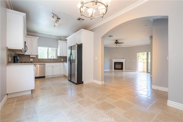 11253 Peach Grove St Unit 106, North Hollywood, CA 91601 - kitchen with appliances with stainless steel finishes, ceiling fan, ornamental molding, healthy amount of natural light, and stone tile flooring