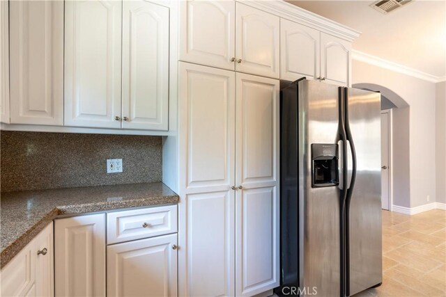 11253 Peach Grove St Unit 106, North Hollywood, CA 91601 - kitchen featuring stainless steel fridge with ice dispenser, arched walkways, crown molding, white cabinetry, and dark countertops