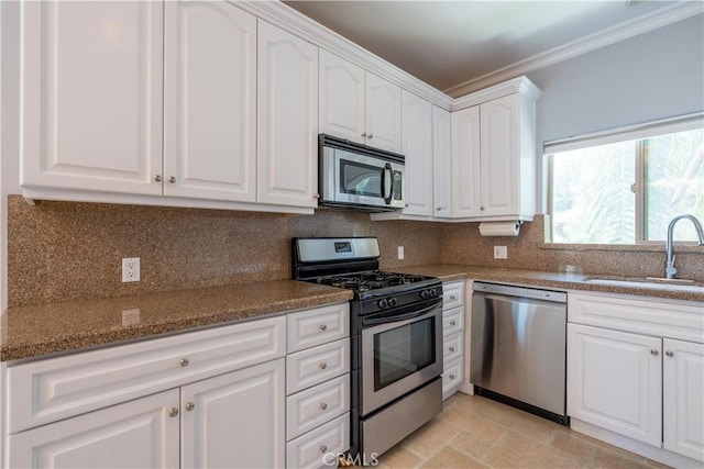 11253 Peach Grove St Unit 106, North Hollywood, CA 91601 - kitchen featuring stainless steel appliances, crown molding, white cabinets, tasteful backsplash, and light stone finish floors
