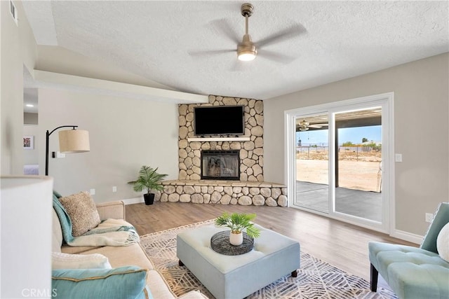 11969 Pinon Ave, Hesperia, CA 92345 - living area featuring a ceiling fan, a textured ceiling, a fireplace, wood finished floors, and vaulted ceiling