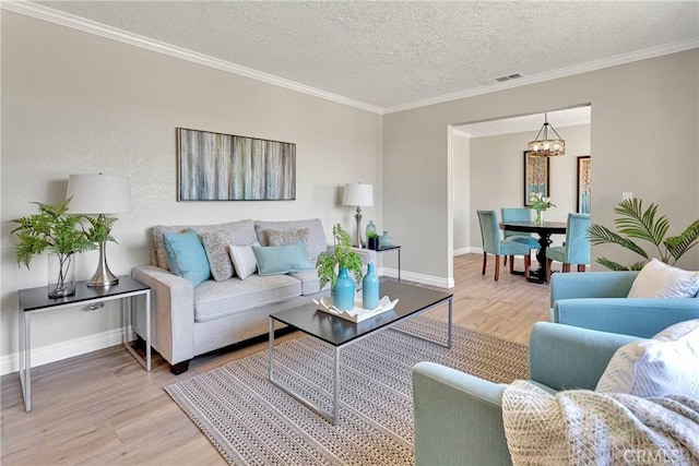 11969 Pinon Ave, Hesperia, CA 92345 - living area with a chandelier, light wood-style flooring, a textured ceiling, and ornamental molding