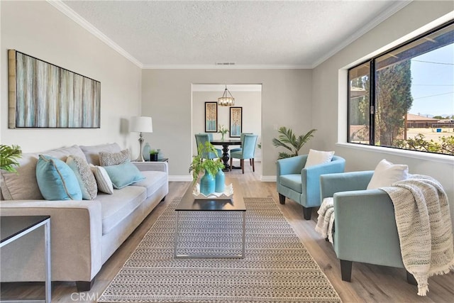 11969 Pinon Ave, Hesperia, CA 92345 - living room featuring wood finished floors, a textured ceiling, ornamental molding, and a chandelier
