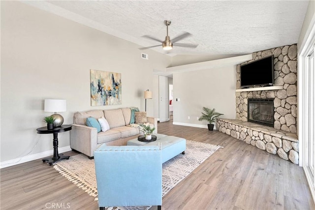 11969 Pinon Ave, Hesperia, CA 92345 - living area with ceiling fan, wood finished floors, a fireplace, and a textured ceiling