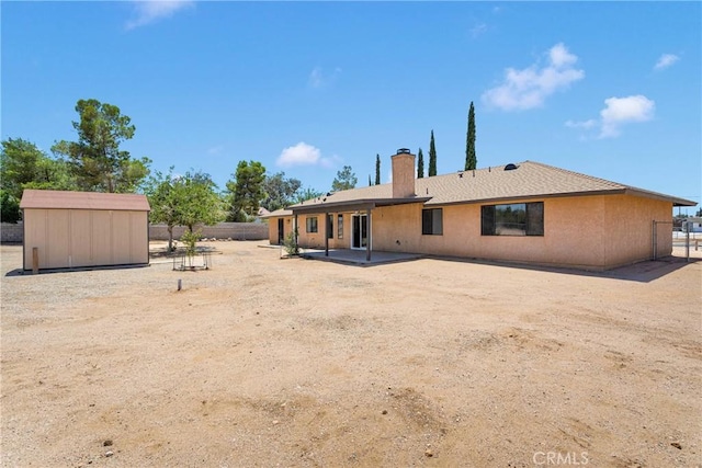 11969 Pinon Ave, Hesperia, CA 92345 - back of property with a chimney, a storage unit, and a patio